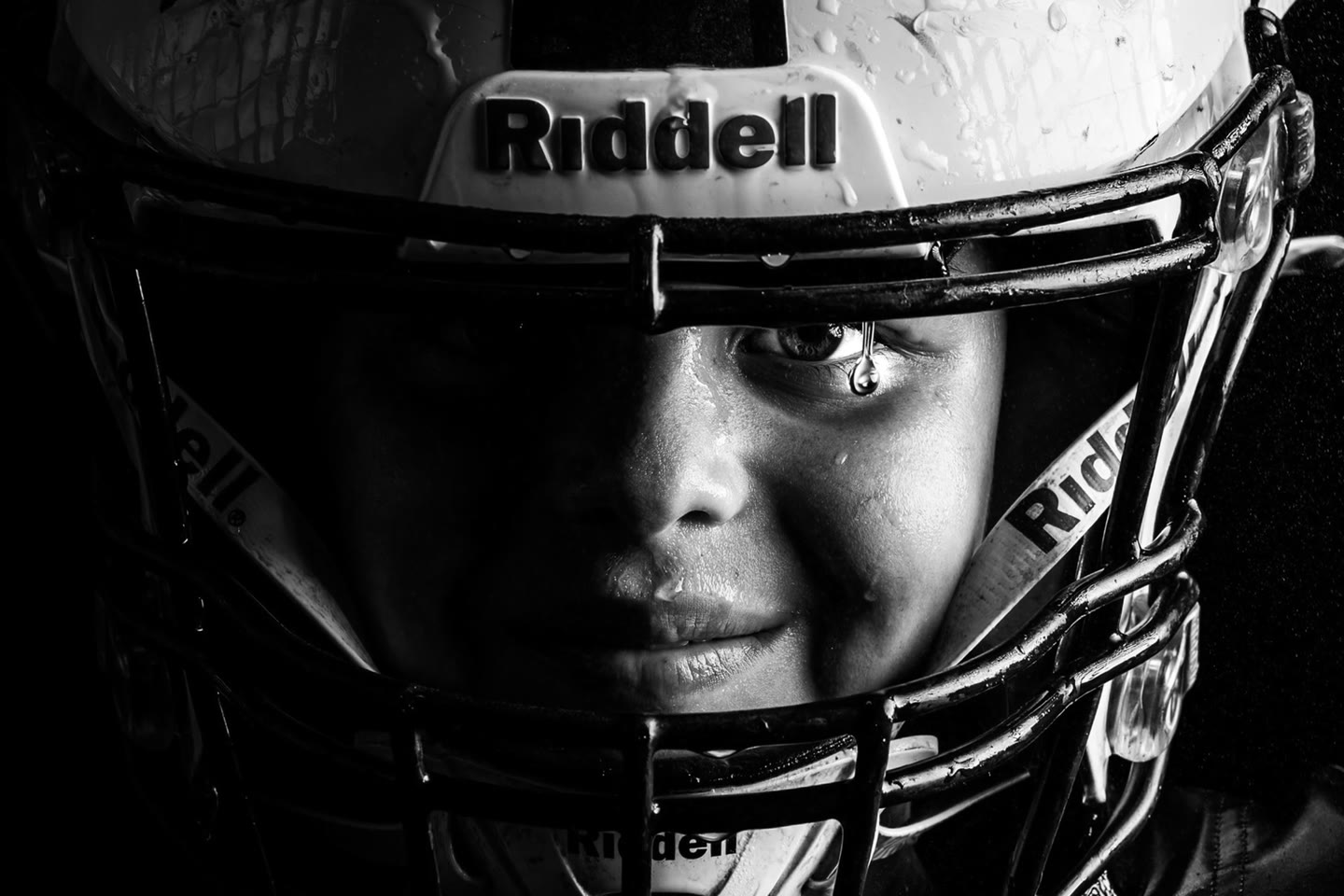 Still from the Geis Studio season film, a young football player in the rain